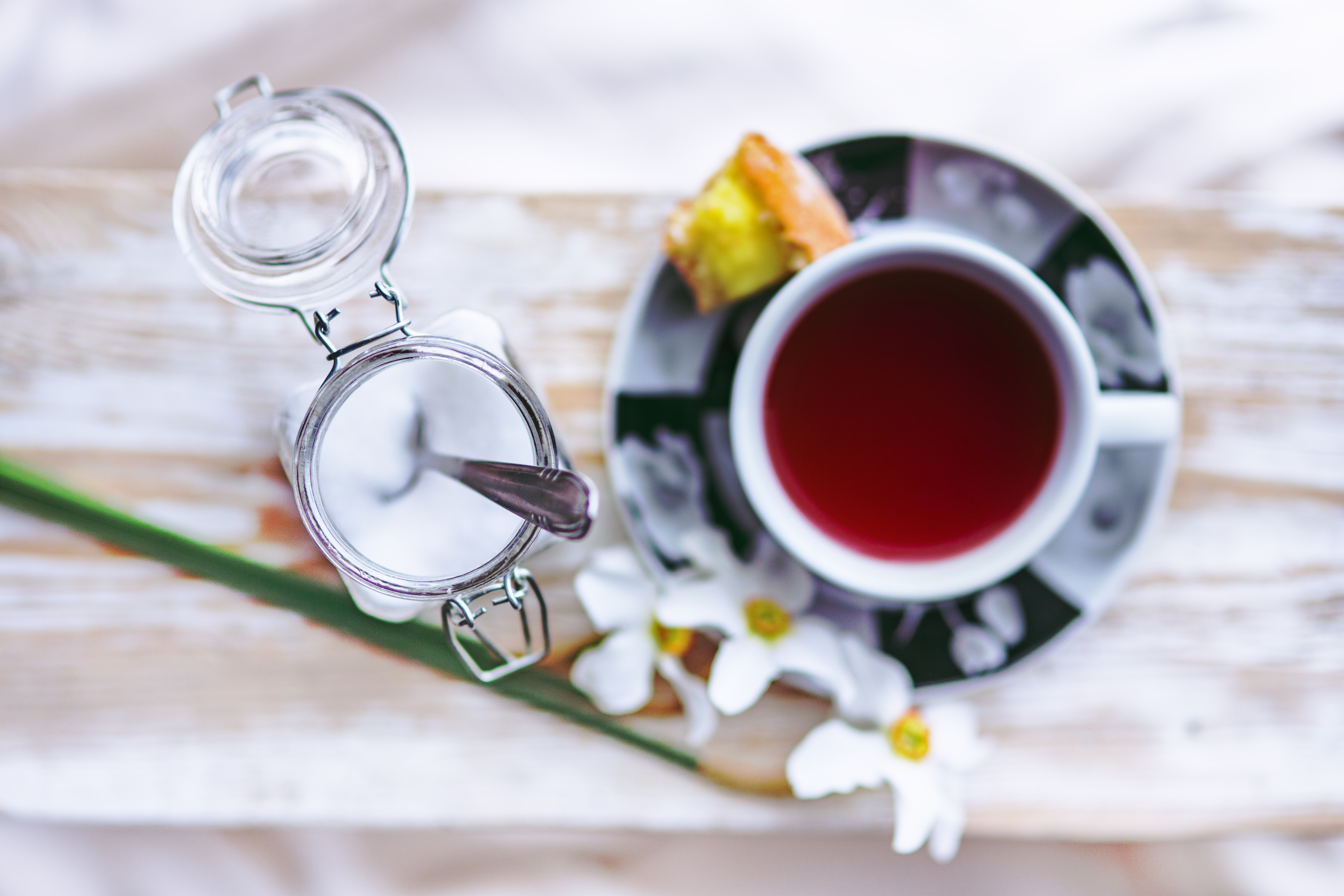 A curious cup of red tea sits on a bold saucer. Don't forget a pinch of sugar.