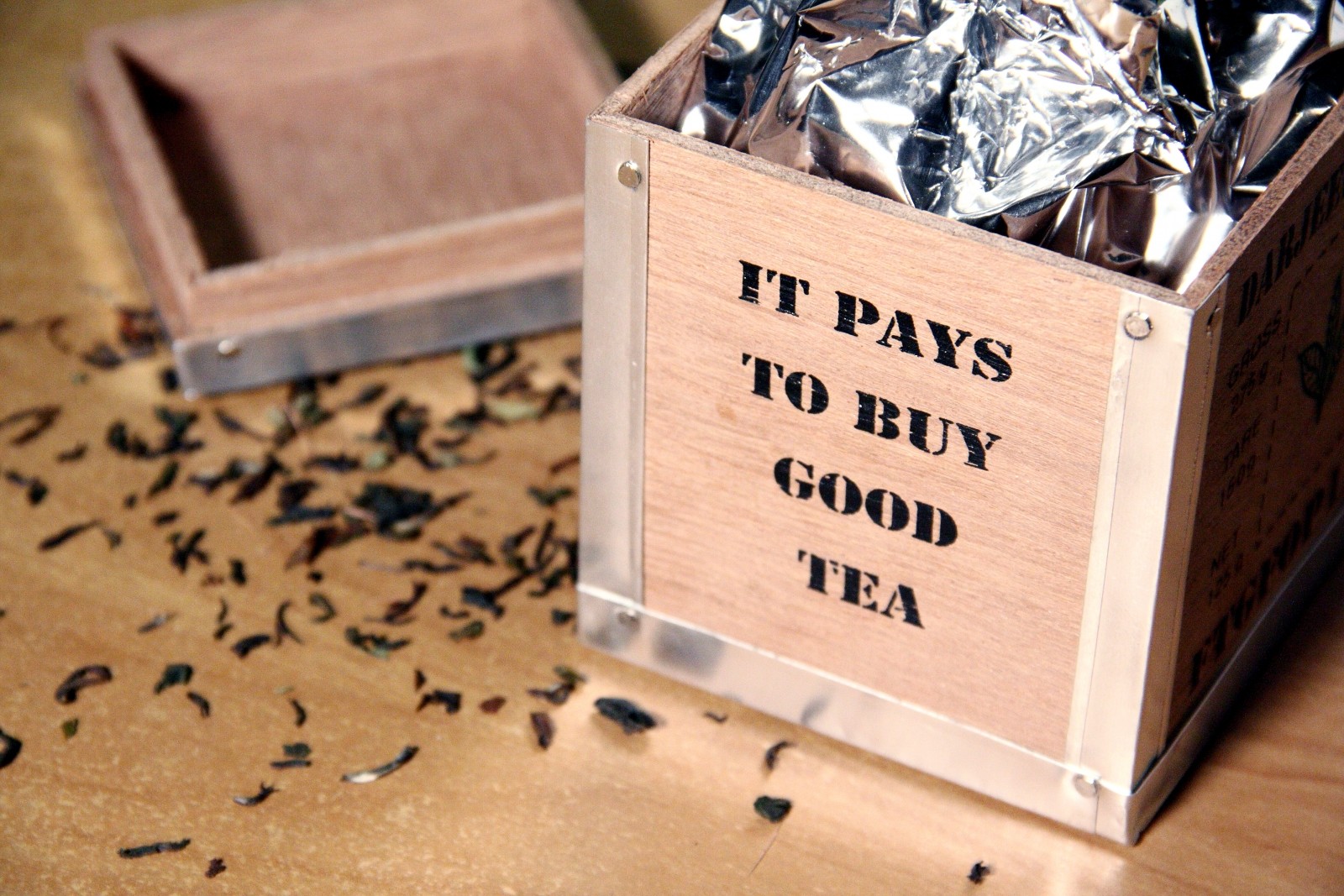 A box with loose tea scattered with it pays to buy good tea. We couldn't agree more